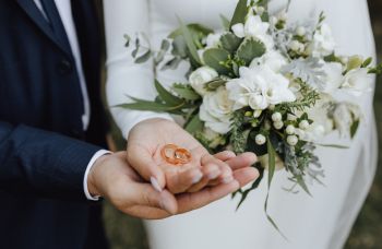 Groom holding the rings and bouquet